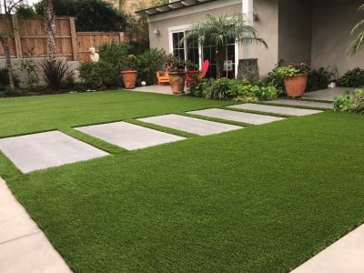 Artificial turf installed around pavers in Plano, TX backyard